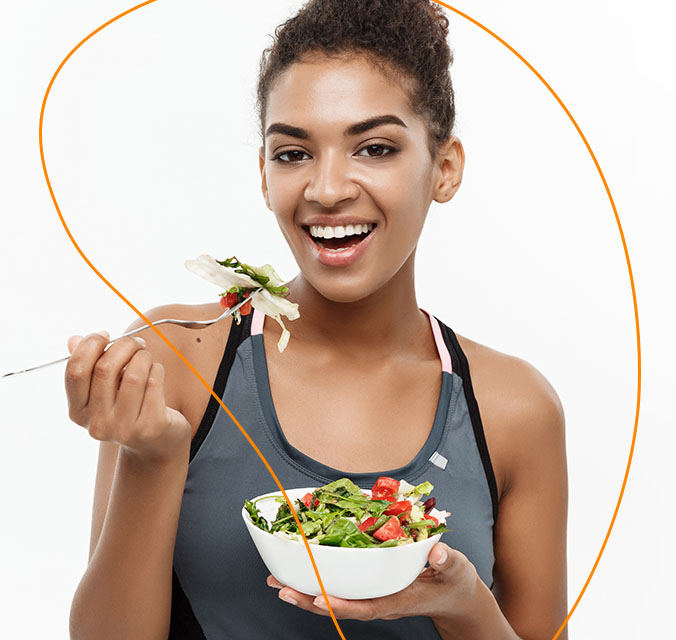 Mulher feliz experimentando sua salada saudável.